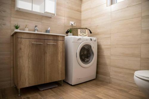 a bathroom with a washing machine and a sink at Ραστώνη in Drama