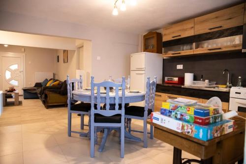 a kitchen with a blue table and chairs in a room at Ραστώνη in Drama