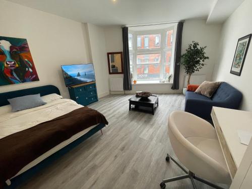 a bedroom with a bed and a blue couch at Beautiful Central Woking Studio in Woking