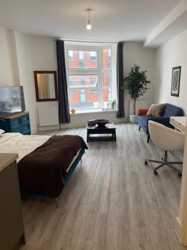 a bedroom with a bed and a living room with a couch at Beautiful Central Woking Studio in Woking