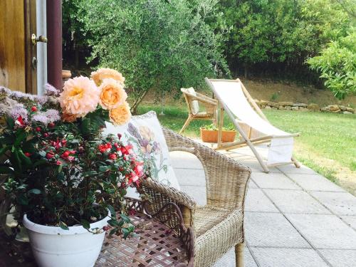a wicker chair and flowers on a patio at Rosso Del Chianti in Panzano