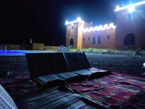 a bench in front of a building at night at DAR AL QANASS IMANE in Midelt