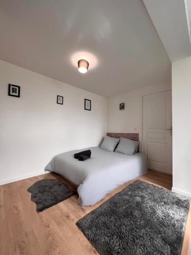 - une chambre blanche avec un lit blanc et un tapis dans l'établissement Studio Cosy spa, à Montmagny
