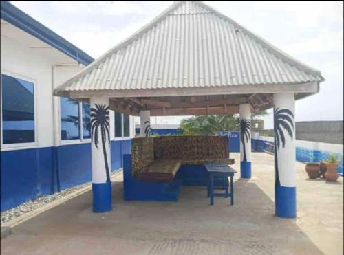 a pavilion with a bench under a roof at Anne’s Beach House in Nyanyanu