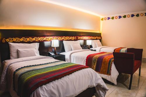 a hotel room with two beds in a room at Altipacha Ayacucho Hotel in Ayacucho