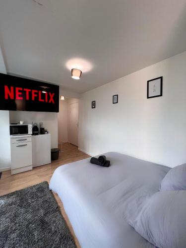 ein Schlafzimmer mit einem Bett mit einem Netflix-Schild an der Wand in der Unterkunft Studio Cosy spa in Montmagny