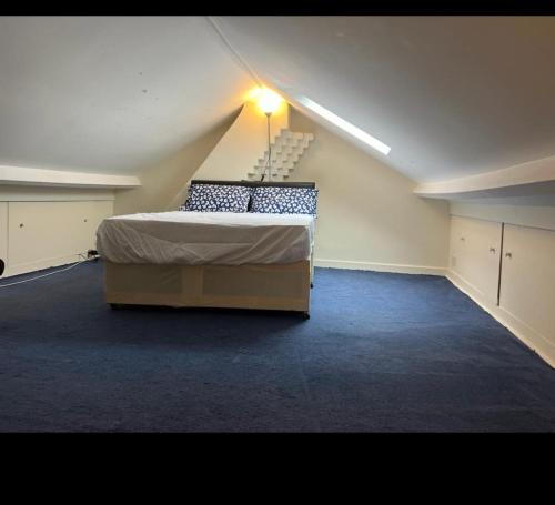 a large room with a bed in an attic at Kenilworth Gardens in Kent