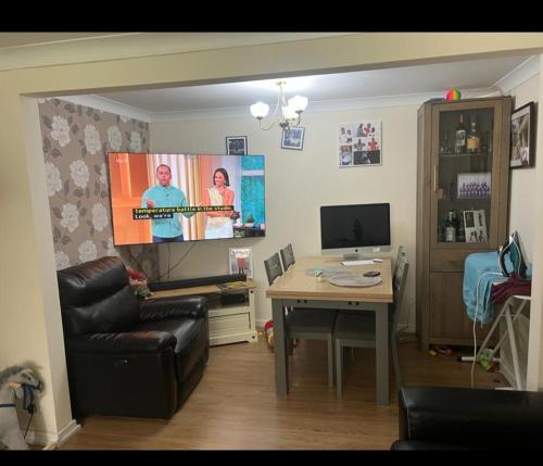 a living room with a couch and a tv and a table at Kenilworth Gardens in Kent