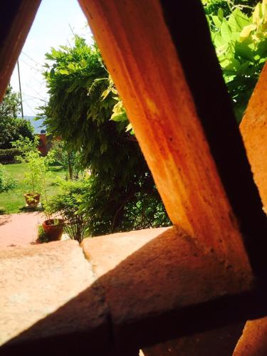 a view of a garden through a wooden fence at Rosso Del Chianti in Panzano