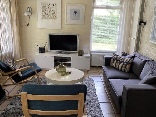 a living room with a couch and a tv at Forest House in Appelscha near National Parks in Appelscha
