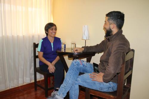Un uomo e una donna seduti a un tavolo con una lampada di Pachamama Hostel a Cuzco