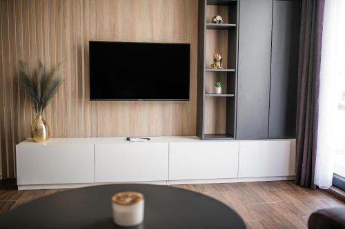 uma sala de estar com uma televisão na parede em NOMAD Apartments em Niš