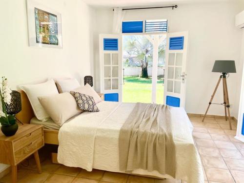 - une chambre avec un lit et une grande fenêtre dans l'établissement BluePalm case, à Petit-Bourg