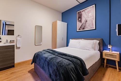 a bedroom with a bed with a blue wall at Mariano Escobedo Apartments by VH in Mexico City