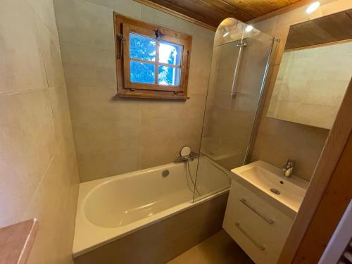 La salle de bains est pourvue d'une baignoire, d'une douche et d'un lavabo. dans l'établissement Chalet Singlinaz, à Zinal