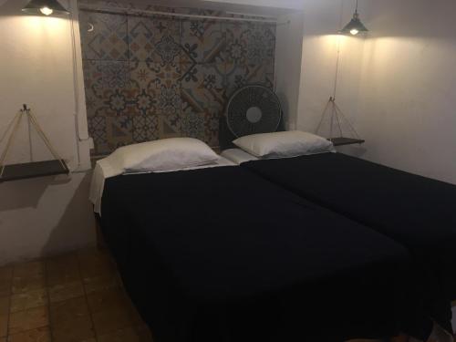 a bedroom with a black bed with two pillows at PATIO Alojamiento in San Miguel de Allende