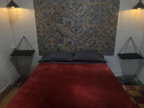 a bed with a red carpet in a room at PATIO Alojamiento in San Miguel de Allende