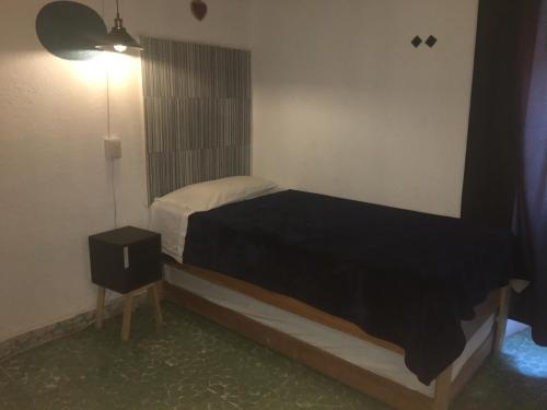 a small bedroom with a bed and a night stand at PATIO Alojamiento in San Miguel de Allende