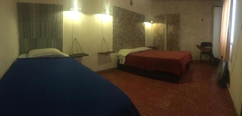 Cette chambre comprend 2 lits et un miroir. dans l'établissement PATIO Alojamiento, à San Miguel de Allende