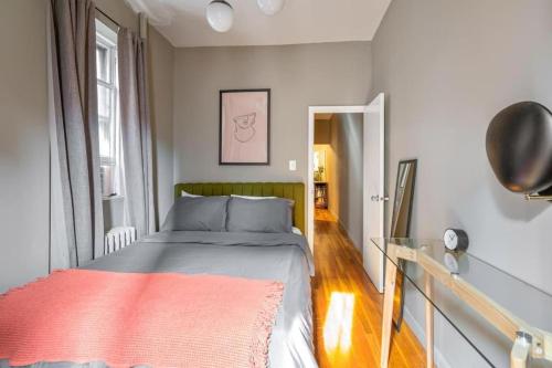 - une chambre avec un lit recouvert d'une couverture orange dans l'établissement Amazing 1Br in Manhattan, à New York