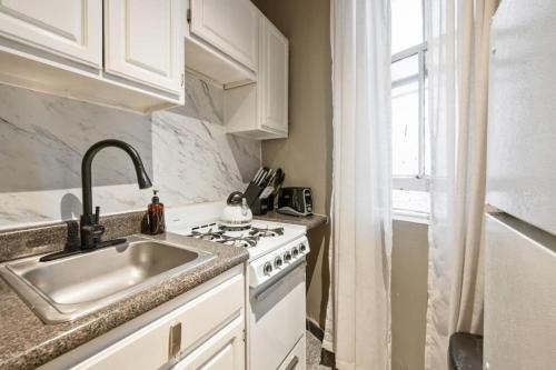 a kitchen with a sink and a stove at Amazing 1Br in Manhattan in New York