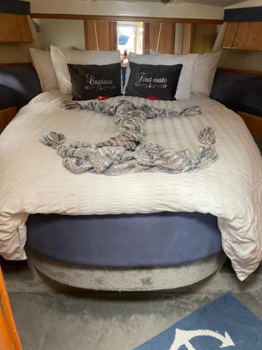 a large bed with a blanket on top of it at ENTIRE LUXURY MOTOR YACHT 70sqm - Oyster Fund - 2 double bedrooms both en-suite - HEATING sleeps up to 4 people - moored on our Private Island - Legoland 8min WINDSOR THORPE PARK 8min ASCOT RACES Heathrow WENTWORTH LONDON Lapland UK Royal Holloway in Egham