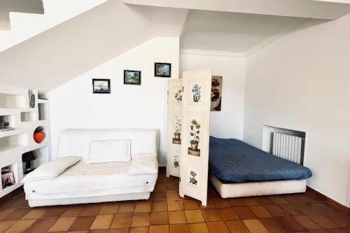 - une chambre blanche avec un lit et une étagère dans l'établissement Rare pearl with pool and sea view, à Mandelieu-la-Napoule