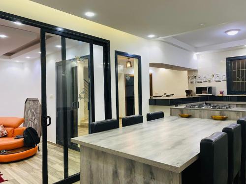 a kitchen with a large wooden table and chairs at Résidence El Hadji Annexe in Dakar