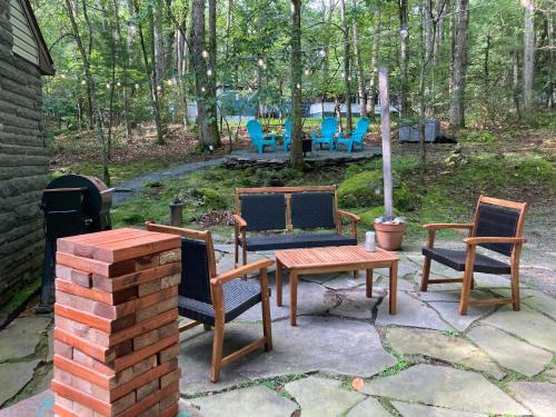 a patio with a table and chairs and a grill at Peaceful Seasonal Wooded Cottage close to everything in Tafton