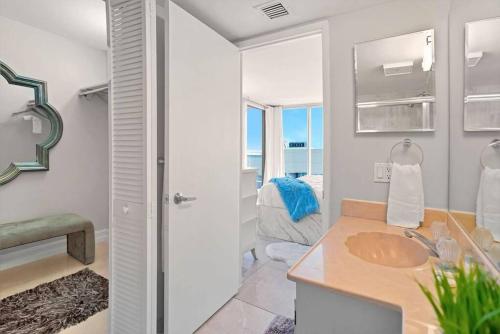 1 dormitorio y baño con lavabo y espejo. en Pisces Dream - Direct water views!, en Miami