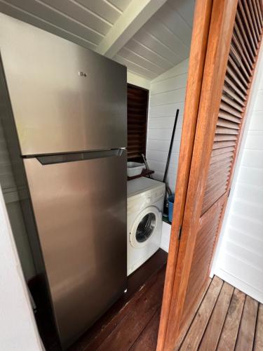 eine Küche mit einem Kühlschrank und einer Waschmaschine in der Unterkunft Case Coco Pointe Batterie. Piscine, vue mer, 4 p. in Deshaies