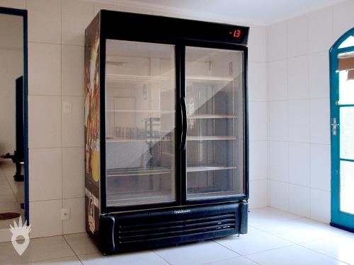 an empty black refrigerator in a room at Linda casa de fazenda no interior de SP in Elias Fausto