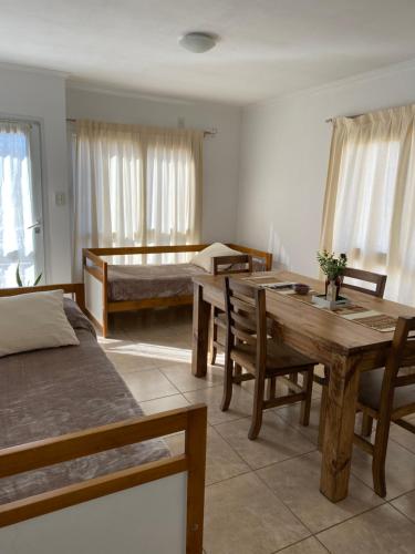 a room with two beds and a table and a bed at Complejo Pampa 2 in Santa Rosa