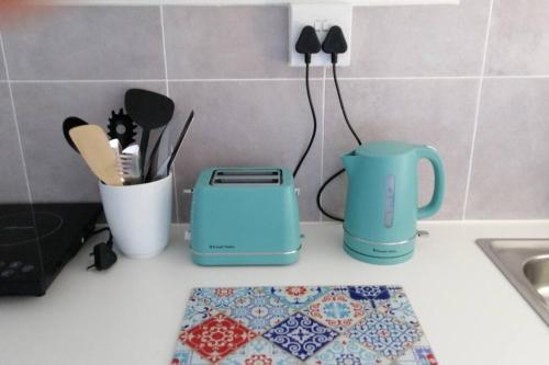 a kitchen counter with a toaster and utensils at SeaViews Holiday Apartment 1 in Cape Town