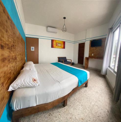 a bedroom with a large bed in a room with blue walls at Hotel Lu Acapulco in Acapulco