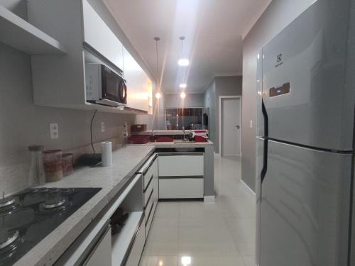 サント・アマロにあるDunas Residence - Casa 10の白いキッチン(冷蔵庫、シンク付)