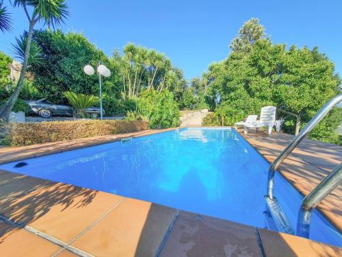 a swimming pool in a yard with a chair at Quintinha das Laranjeiras in Santa Cruz do Douro