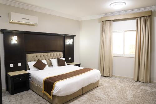Habitación de hotel con cama grande y ventana en عنوانك للشقق المخدومة en Abha