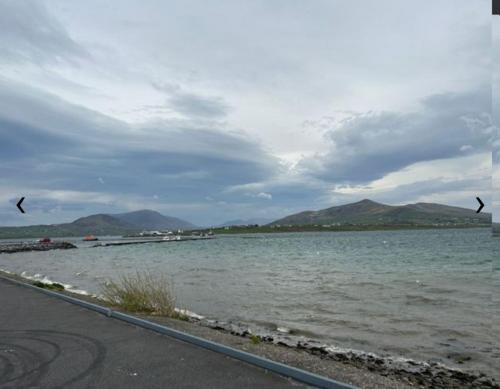 a body of water with two birds flying over it at Valentia Skellig Rooms - 7 km away from Portmagee in Valentia Island