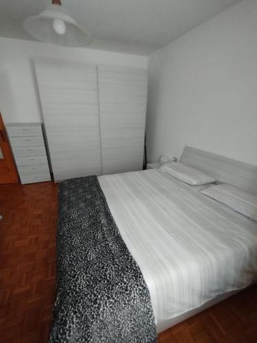 Schlafzimmer mit einem weißen Bett und einem Deckenventilator in der Unterkunft Ca Bellavista in Chiesa in Valmalenco