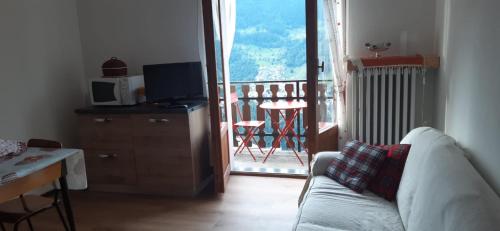 ein Wohnzimmer mit einem Sofa und einem Balkon in der Unterkunft Ca Bellavista in Chiesa in Valmalenco