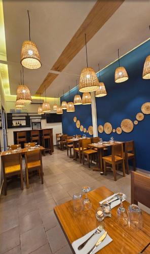 a restaurant with wooden tables and chairs and chandeliers at Nandy's home in Odza II