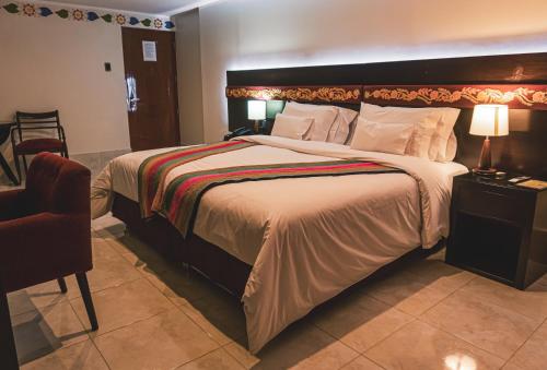 a bedroom with a large bed with a large headboard at Altipacha Ayacucho Hotel in Ayacucho