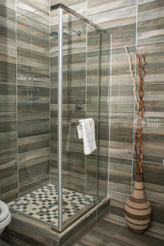baño con cabina de ducha con puerta de cristal en Kendi's Inn Guest House, en Jwaneng