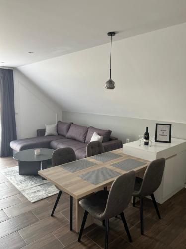 uma sala de estar com um sofá e uma mesa em NOMAD Apartments em Niš