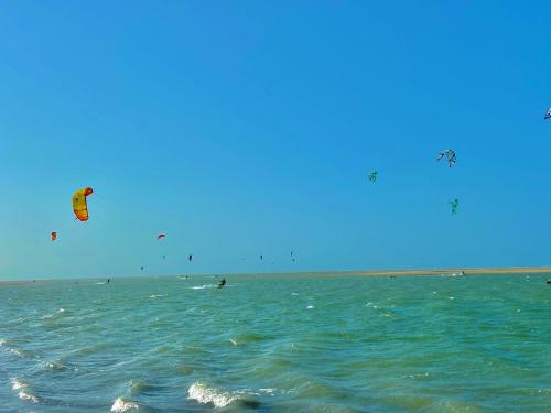 a group of people kite surfing in the ocean at Casa Praia Beira Mar "TÉRREO" Guriú,Ce in Guriú