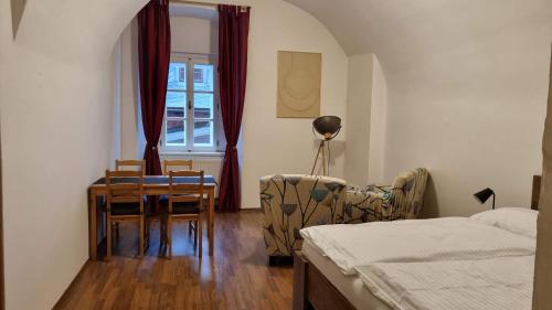 sypialnia z łóżkiem, stołem i krzesłami w obiekcie neVINNÉ Apartmány w mieście Kolín