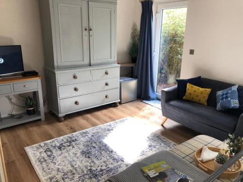 sala de estar con sofá y cómoda en Orchard house guest studio accommodation en Marchwiel