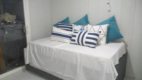 a bed with blue and white pillows on it at Blue Sand House B&B in Cartagena de Indias