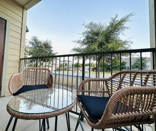 three wicker chairs and a table on a balcony at Luxe 2B/2B Getaway - Pool, Gym, Garage, Pet Wash in Leander